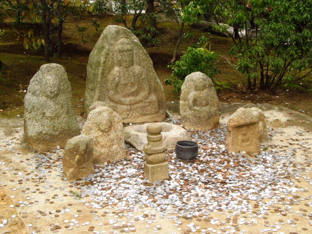 People tossing coins at naturally formed Buddha images in the rocks, to bring good luck!